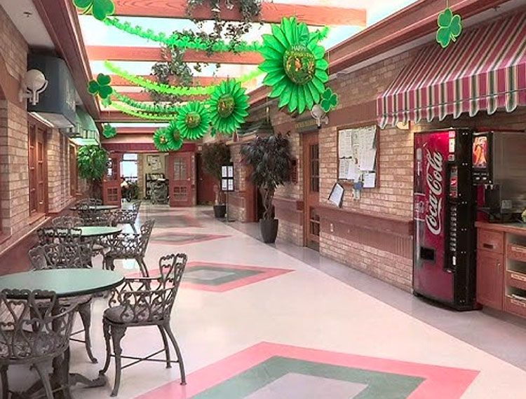 A coca cola vending machine in a hallway decorated for st. patrick 's day