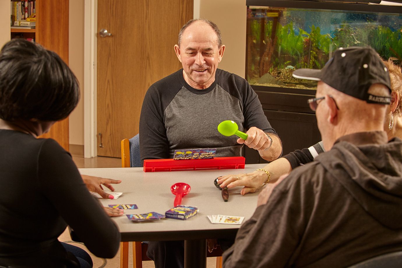 Group of adult day program participants engaged in activities around a table