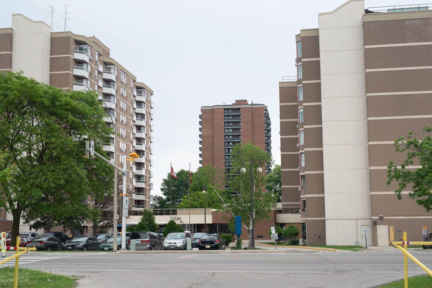 A row of tall buildings with cars parked in front of them