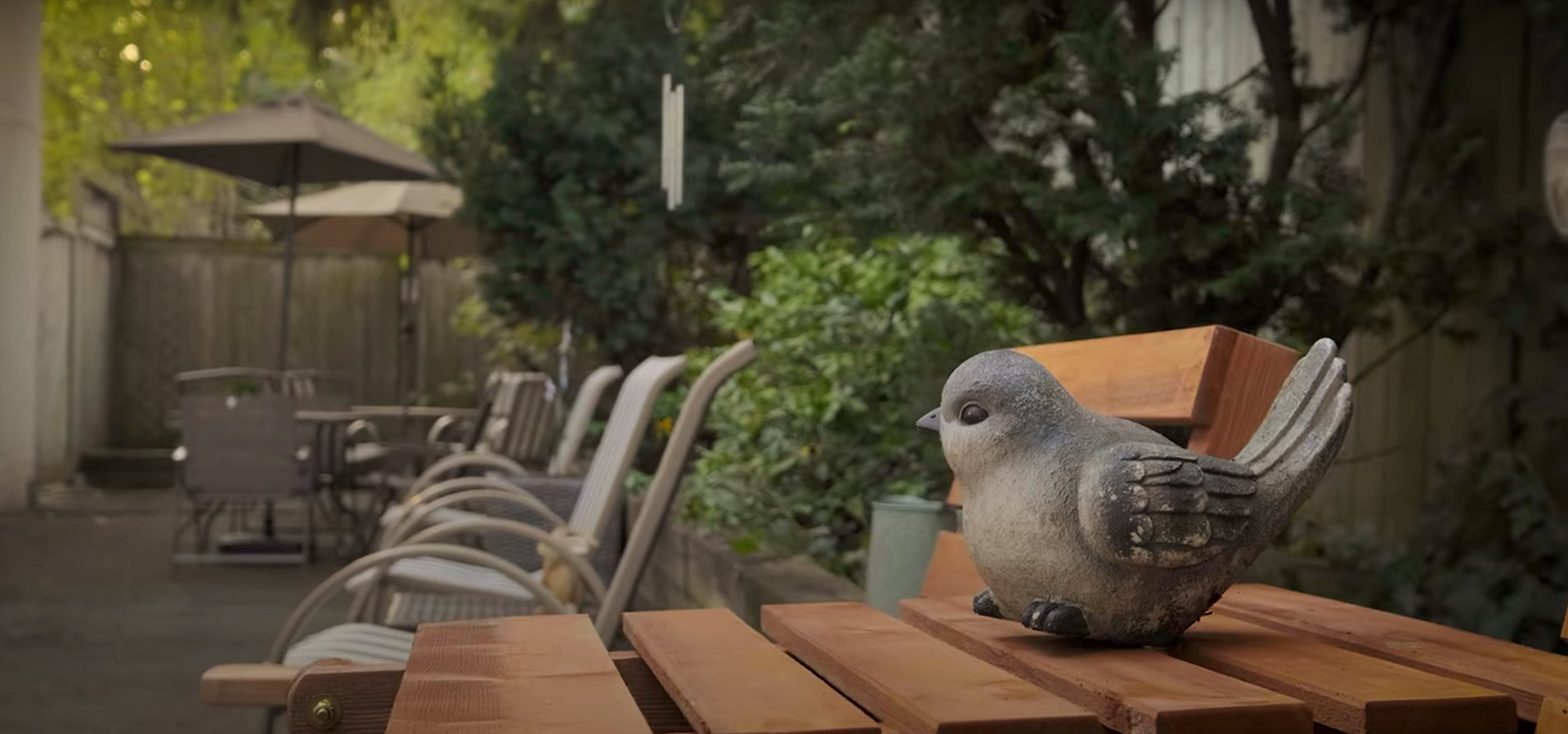 A statue of a bird is sitting on a wooden table.