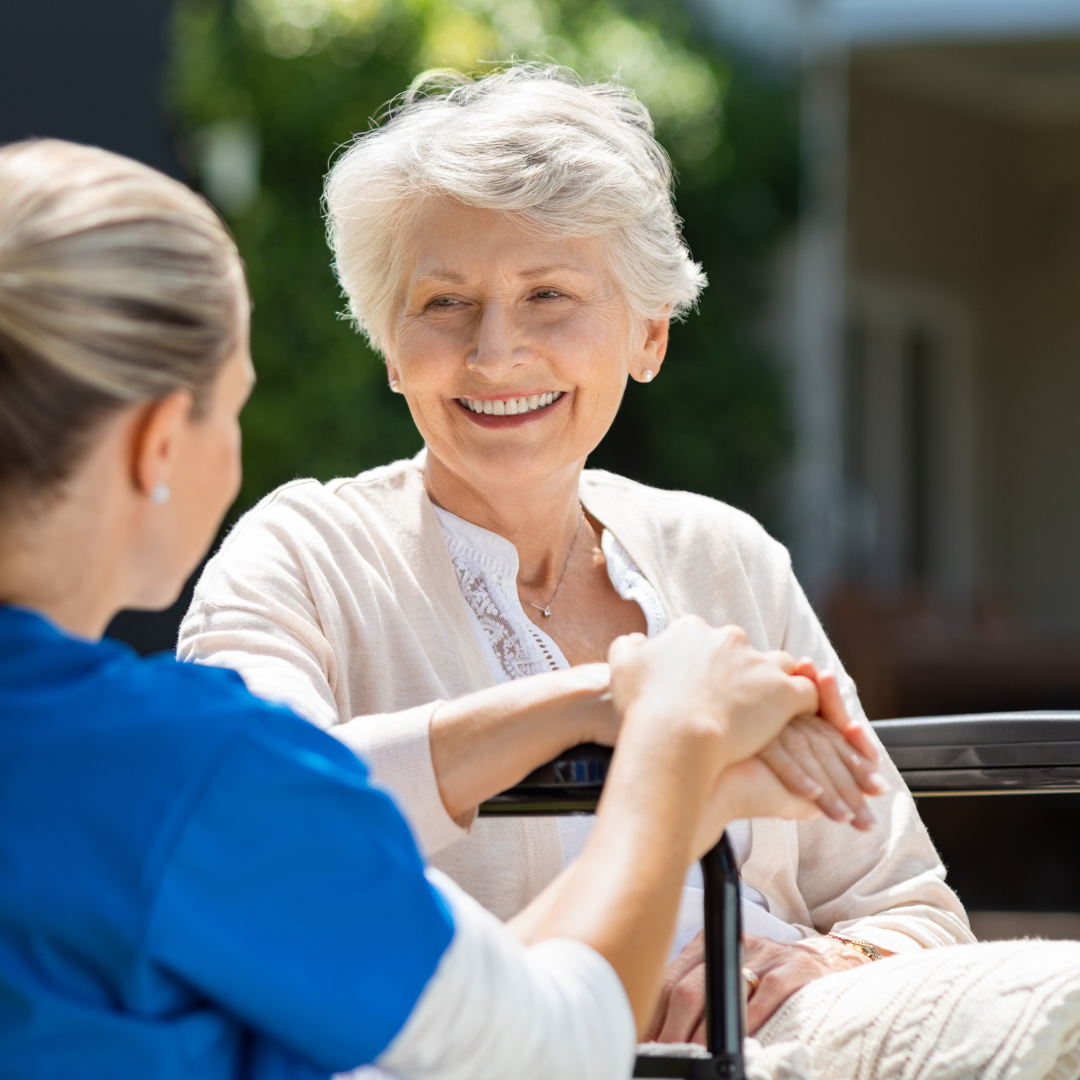 A nurse is talking to an elderly woman in a wheelchair.
