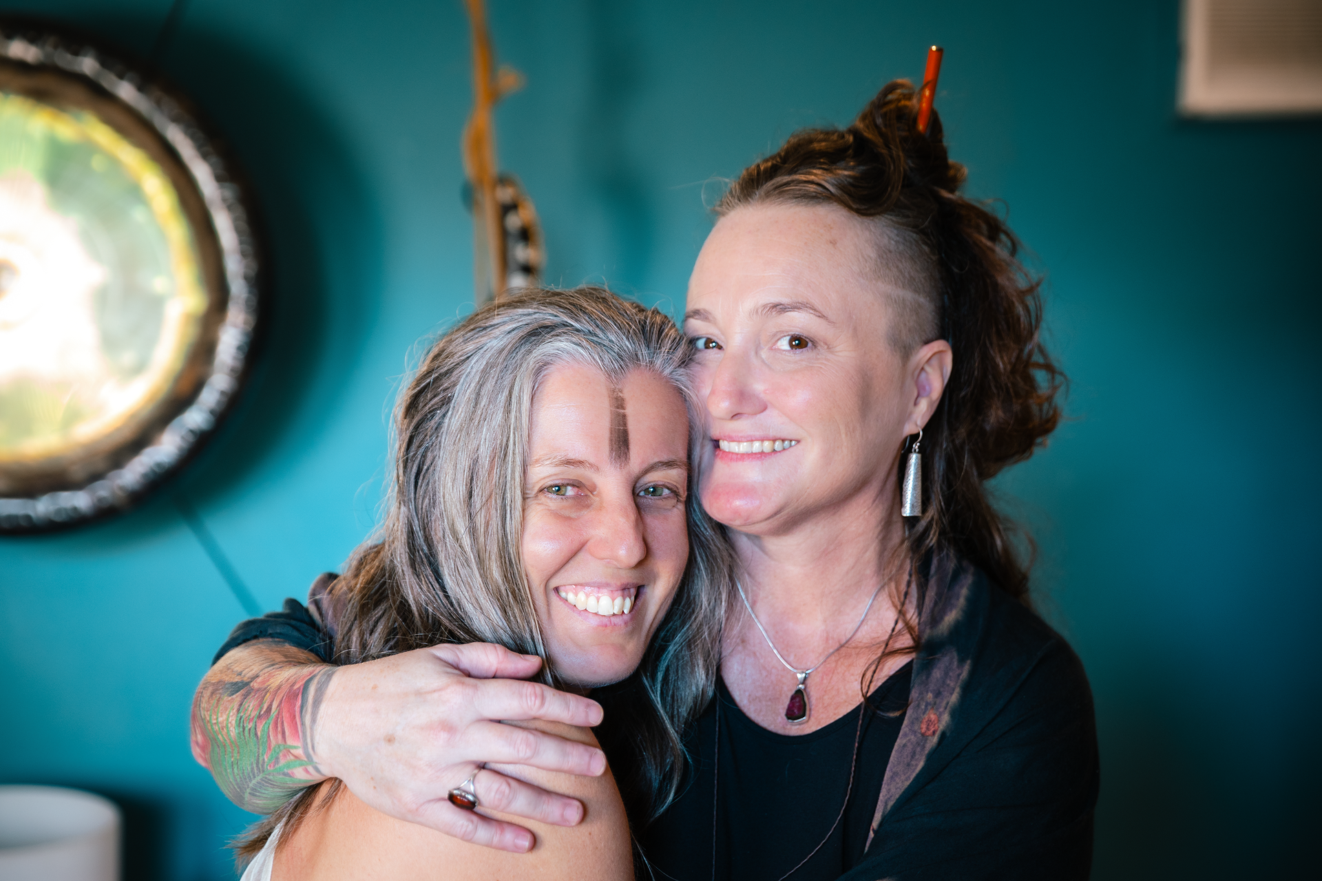 Two women are hugging each other and smiling for the camera.