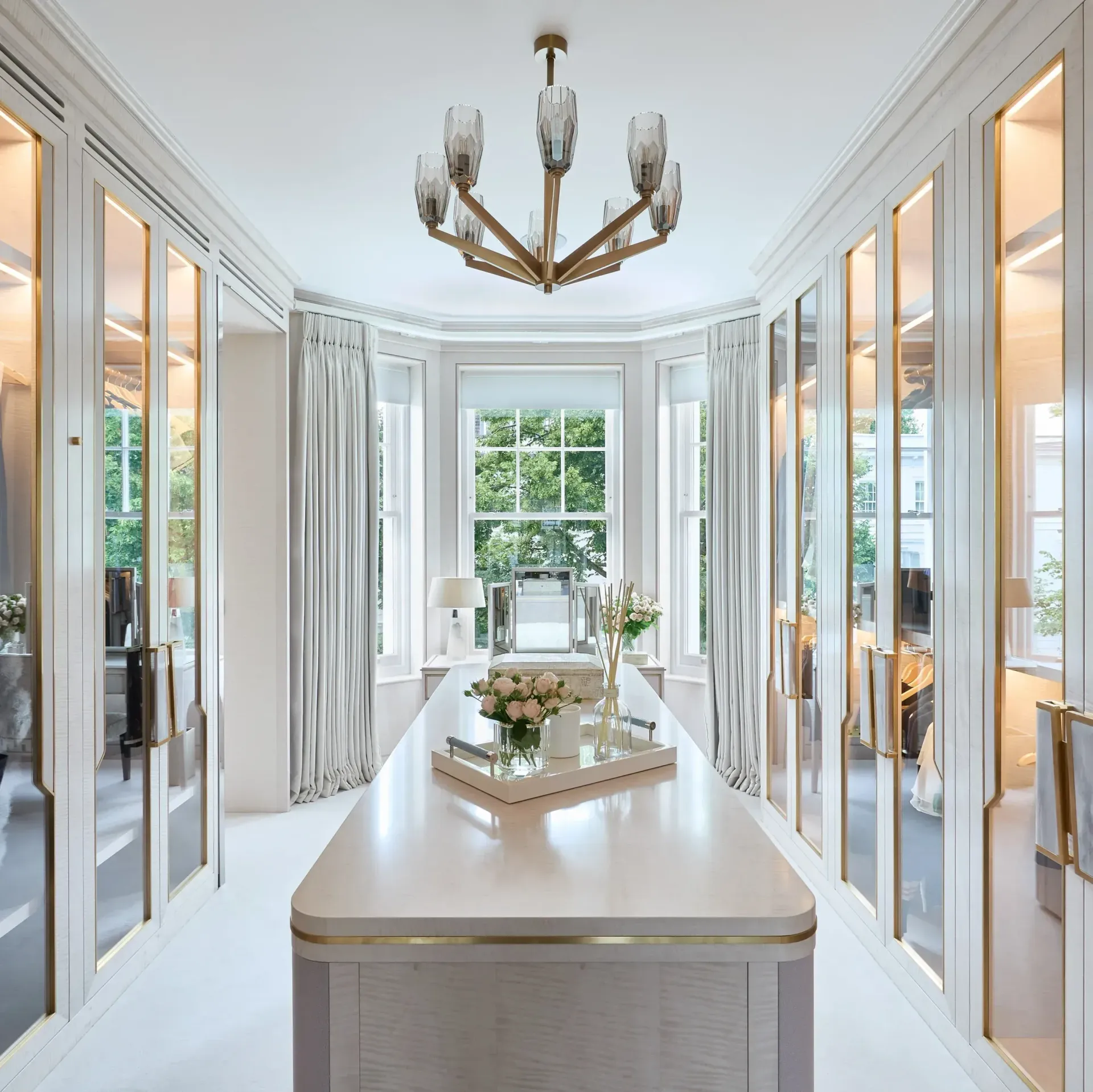 Woman with light brown hair, wearing a black top and silver earrings, looking toward the viewer.