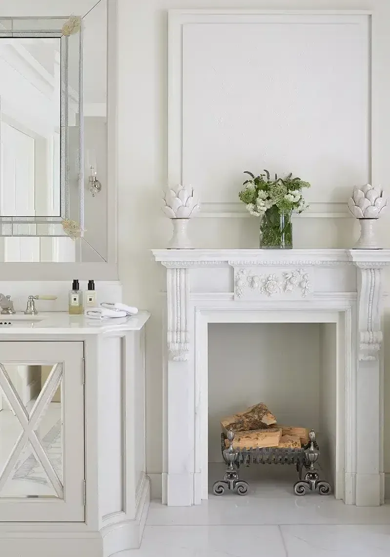 Living room with blue accents, featuring a bar cabinet, velvet chair, and patterned rug.