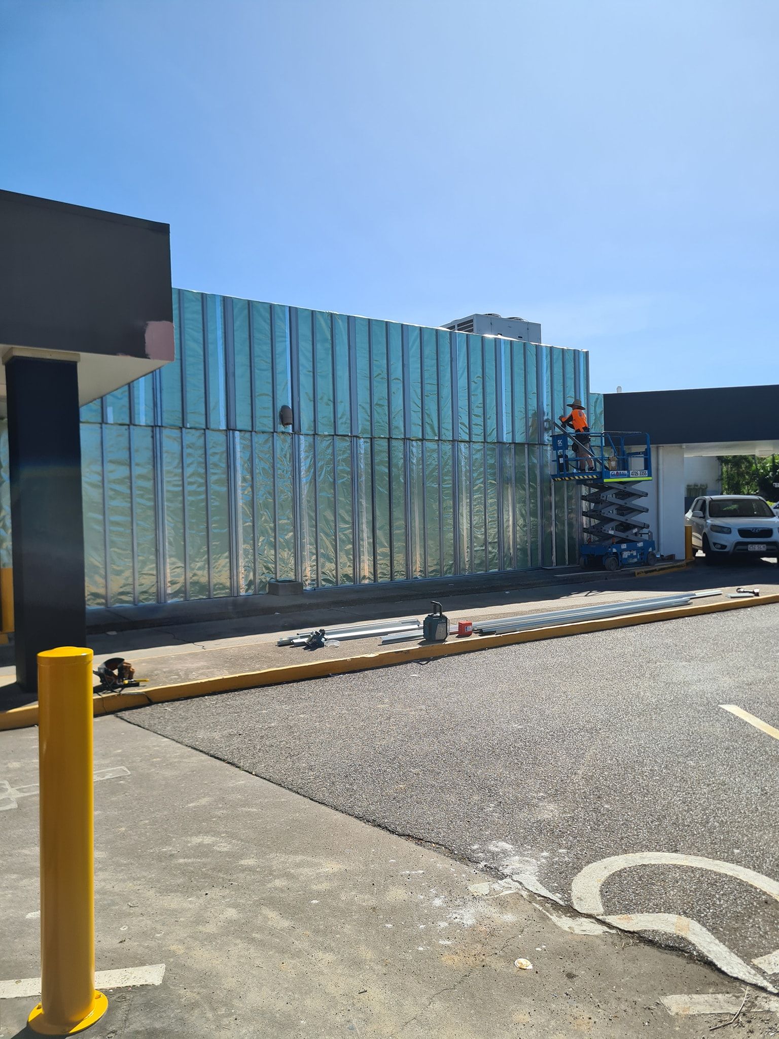 A Construction Worker Is Standing in Front of A Building Under Construction — Iconic Construction Industries in Garbutt, QLD