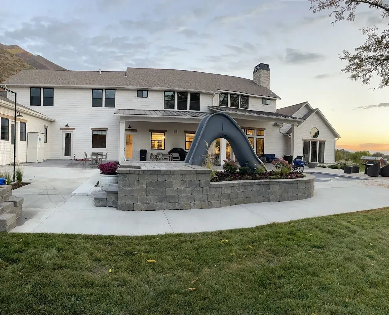 A large white house with a slide in the backyard