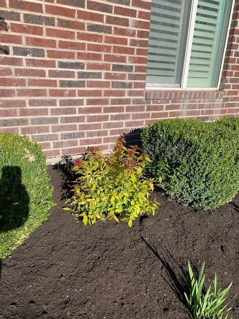 A brick house with a garden in front of it.