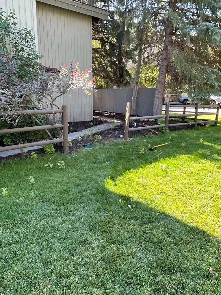 There is a wooden fence in the backyard of a house.