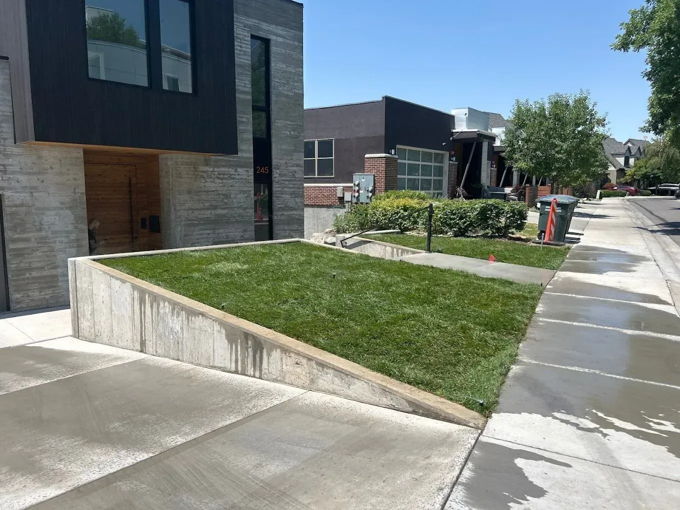 A sidewalk with a grassy area in front of a building