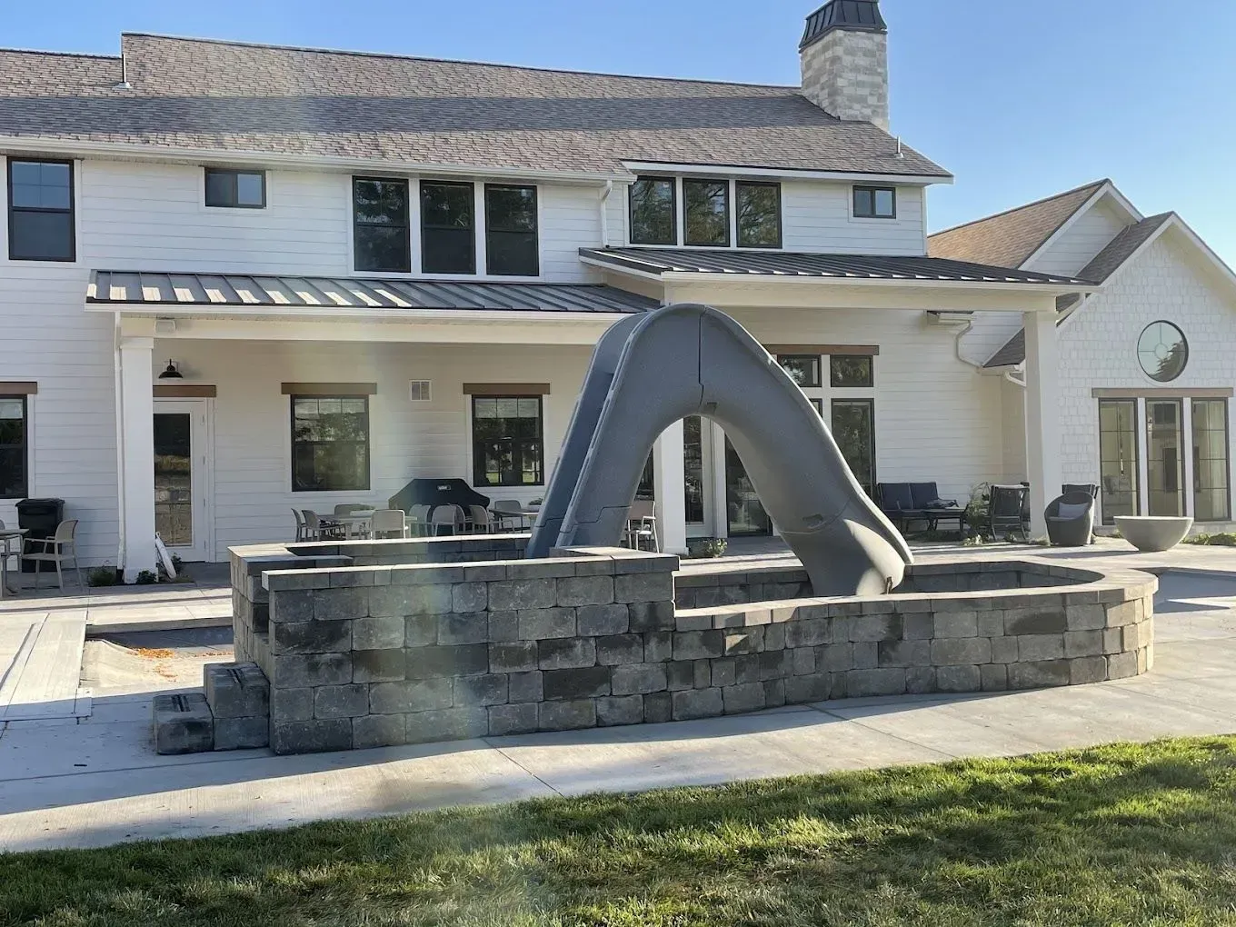 A large white house with a large slide in front of it.