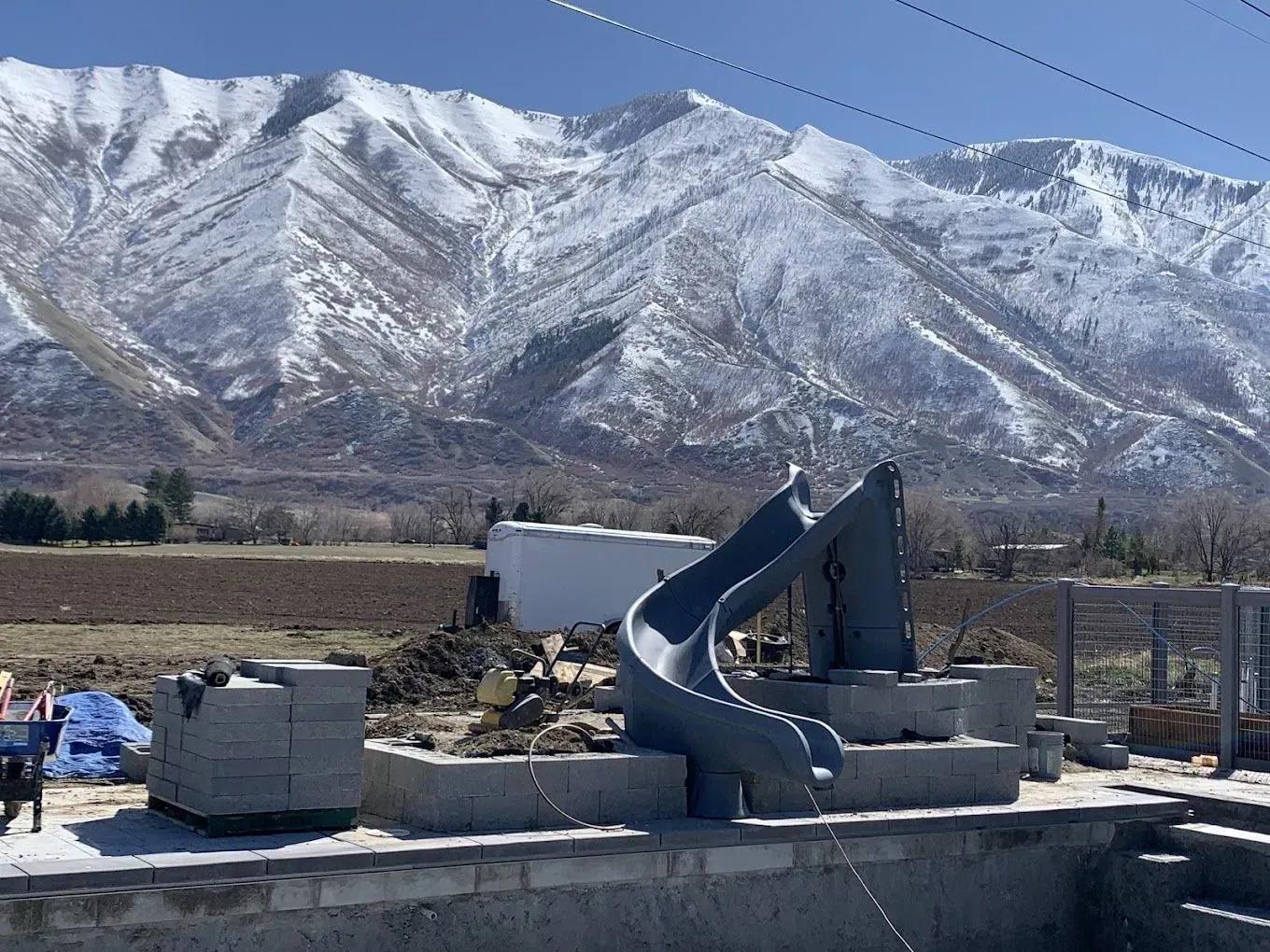 A slide is being built in front of a snowy mountain