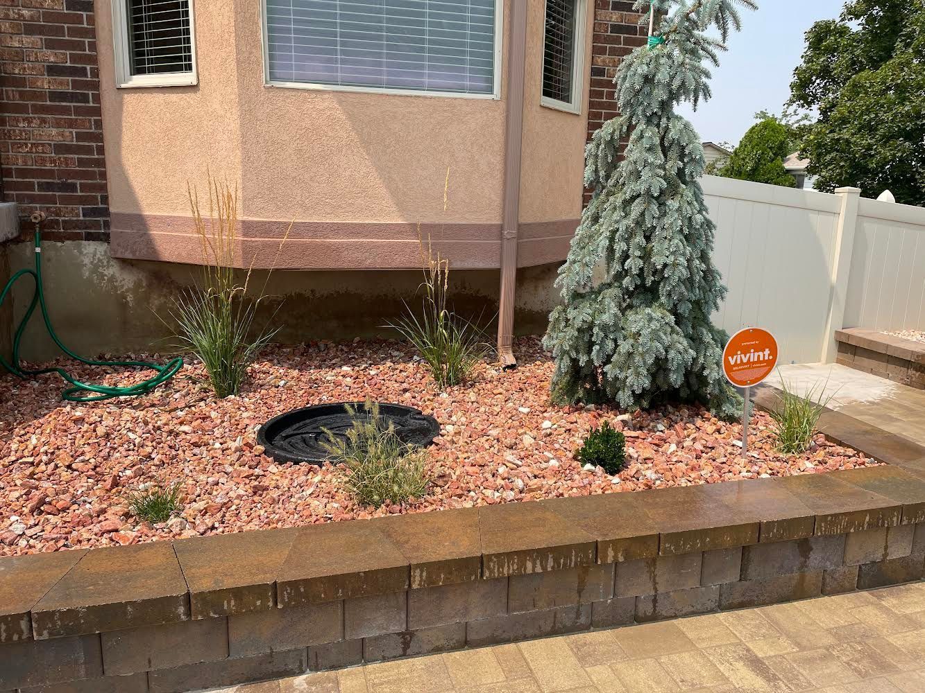 A garden with gravel and plants in front of a house.
