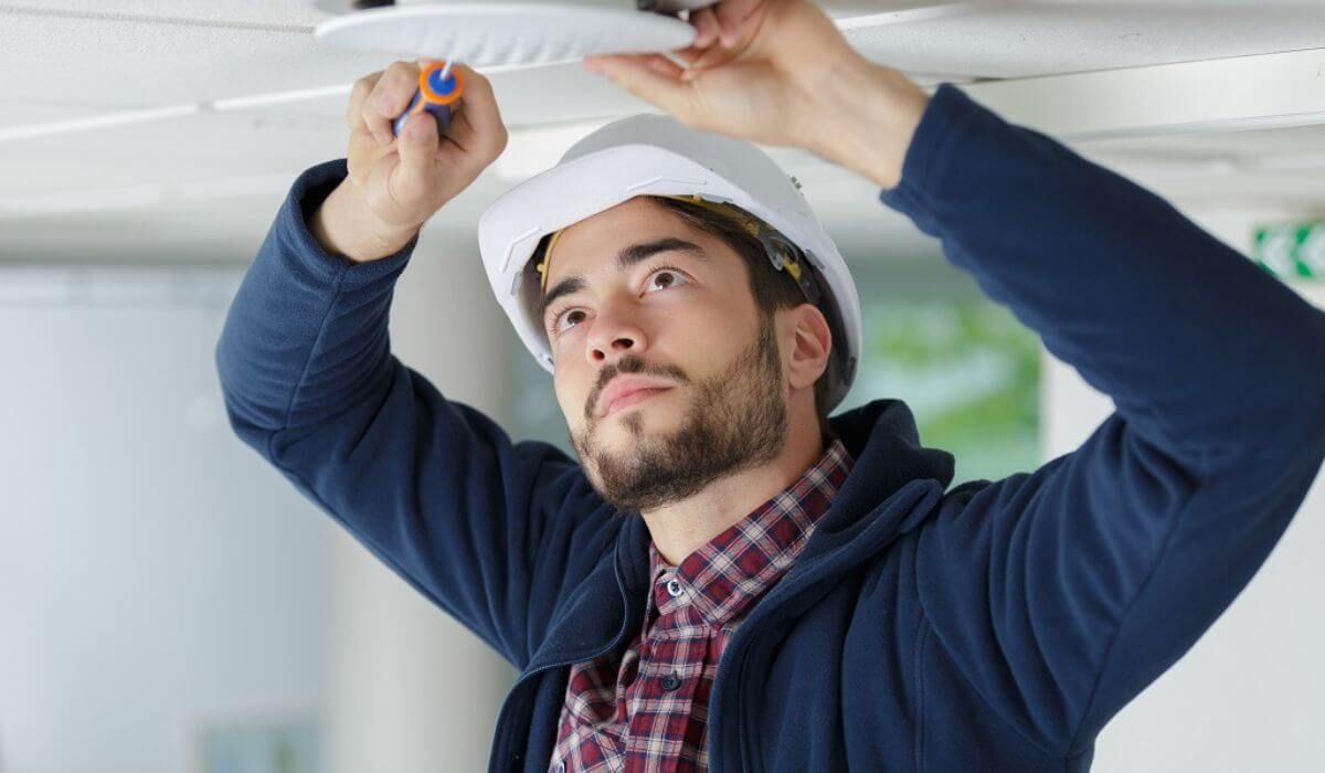 Professional electrician installing fire alarm