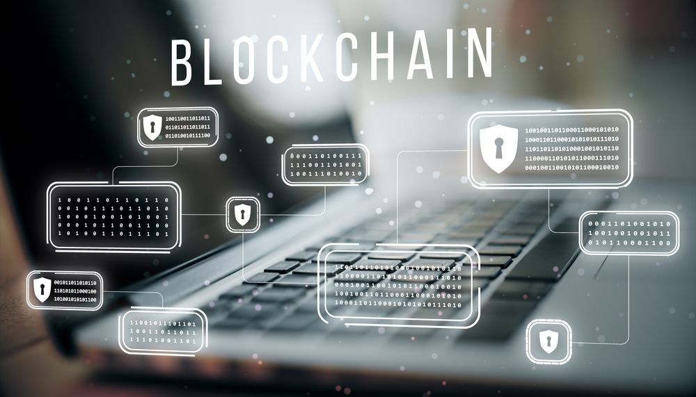 A laptop computer with the word blockchain on the screen.
