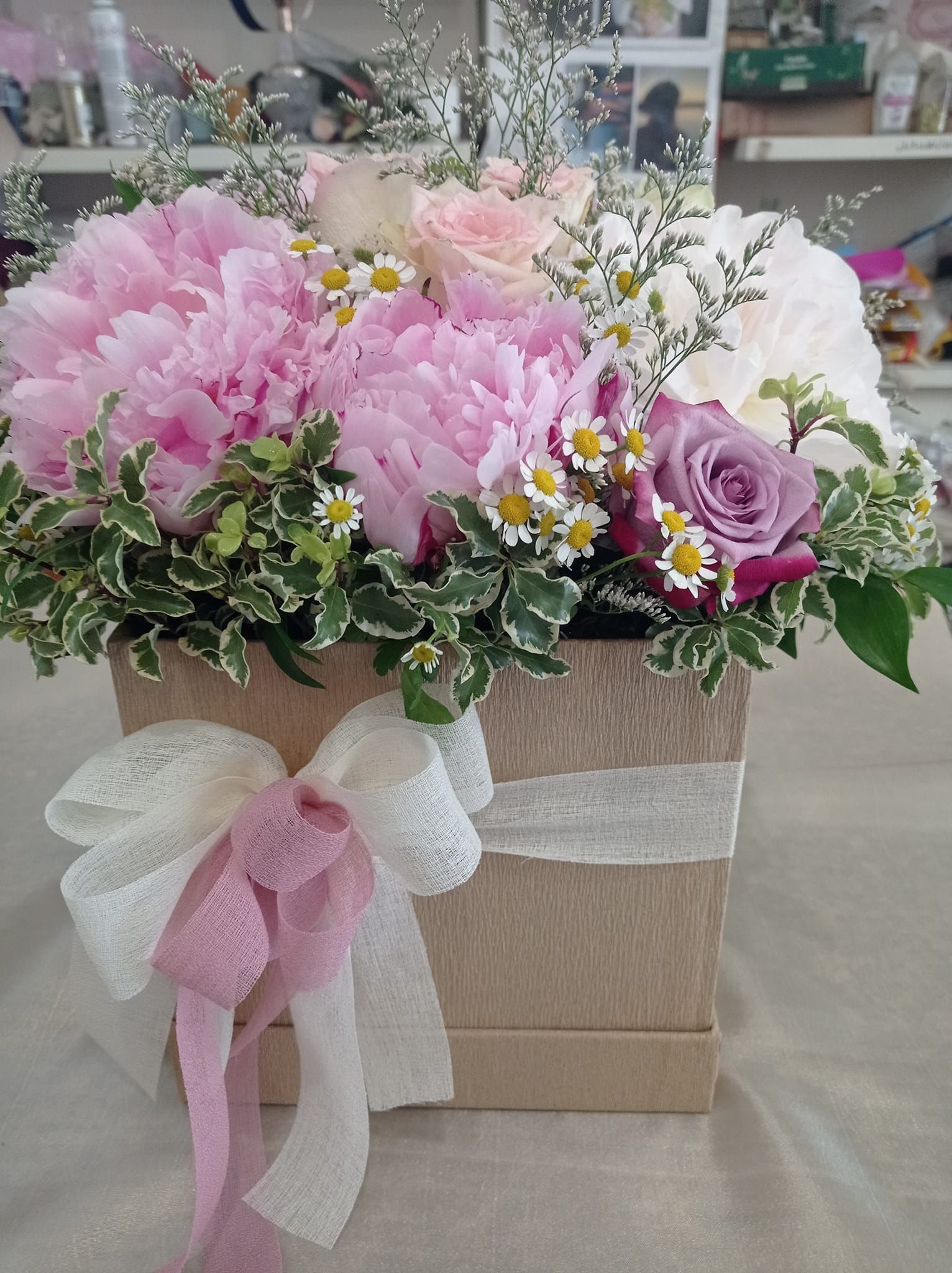 Una scatola piena di fiori rosa e bianchi