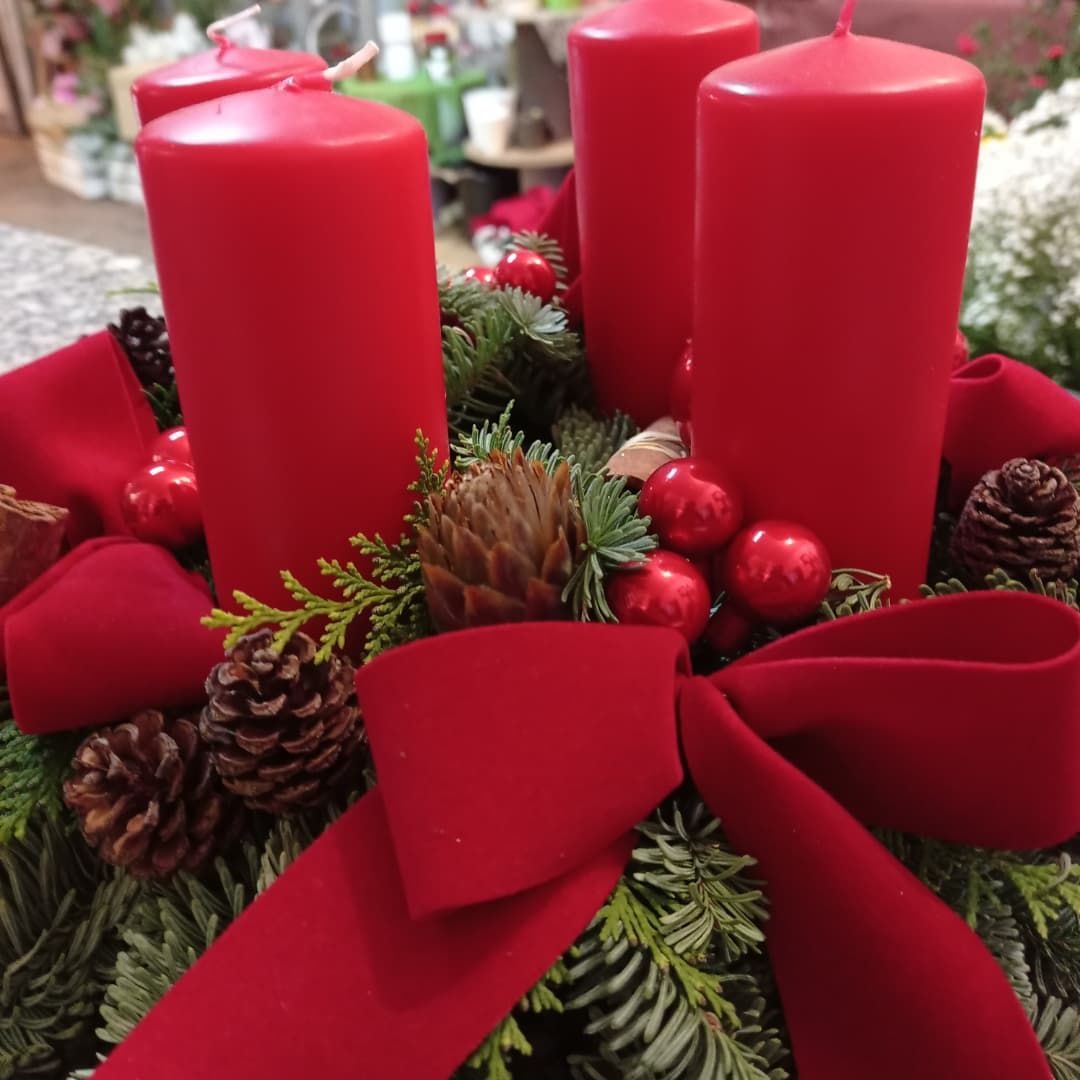 Una corona natalizia con candele rosse