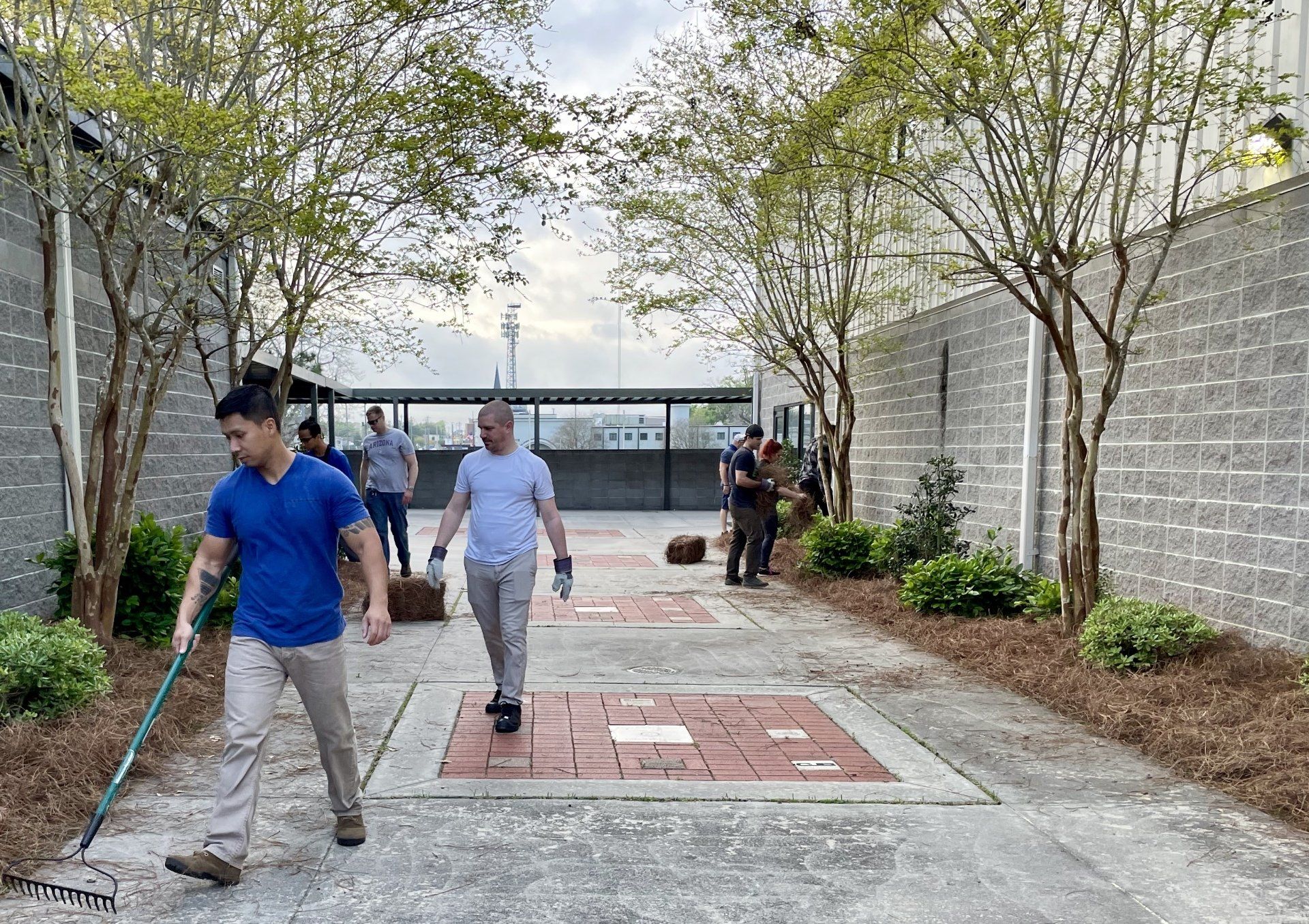 Adults doing landscaping outside Boys & Girls Club building