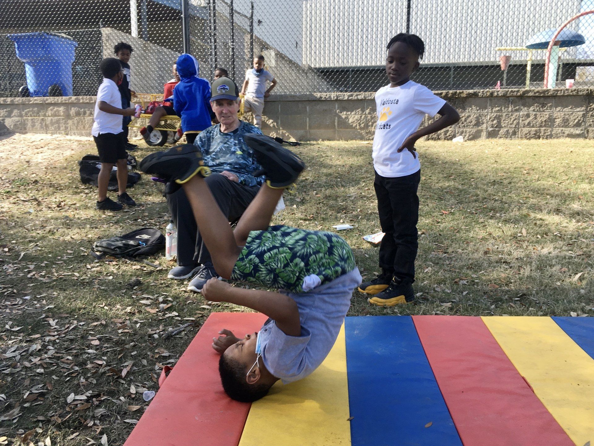 Kids playing with colorful mat outdoors at Boys & Girls Club