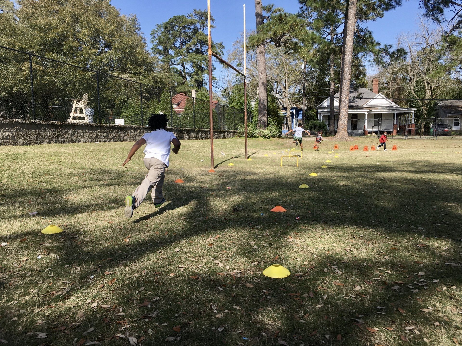Boy running across outdoor field activity at Boys & Girls Club