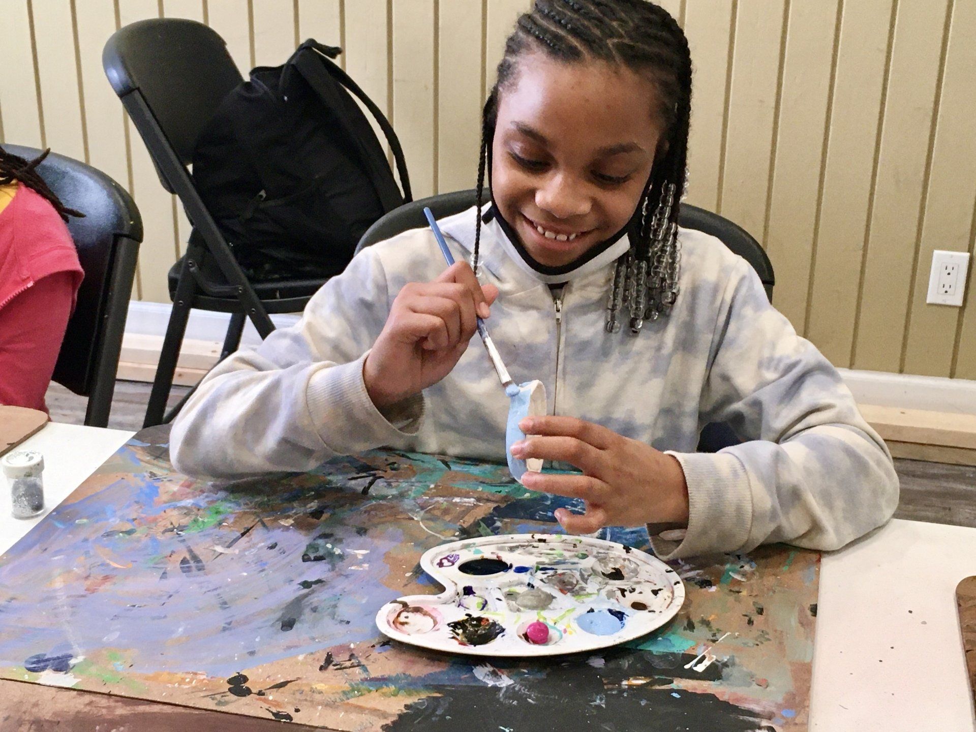 Girl smiling while painting at Boys & Girls Club