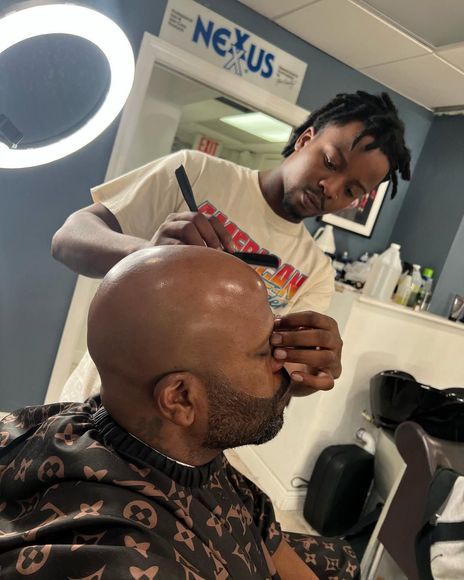 Man getting a beard trim with a straight razor