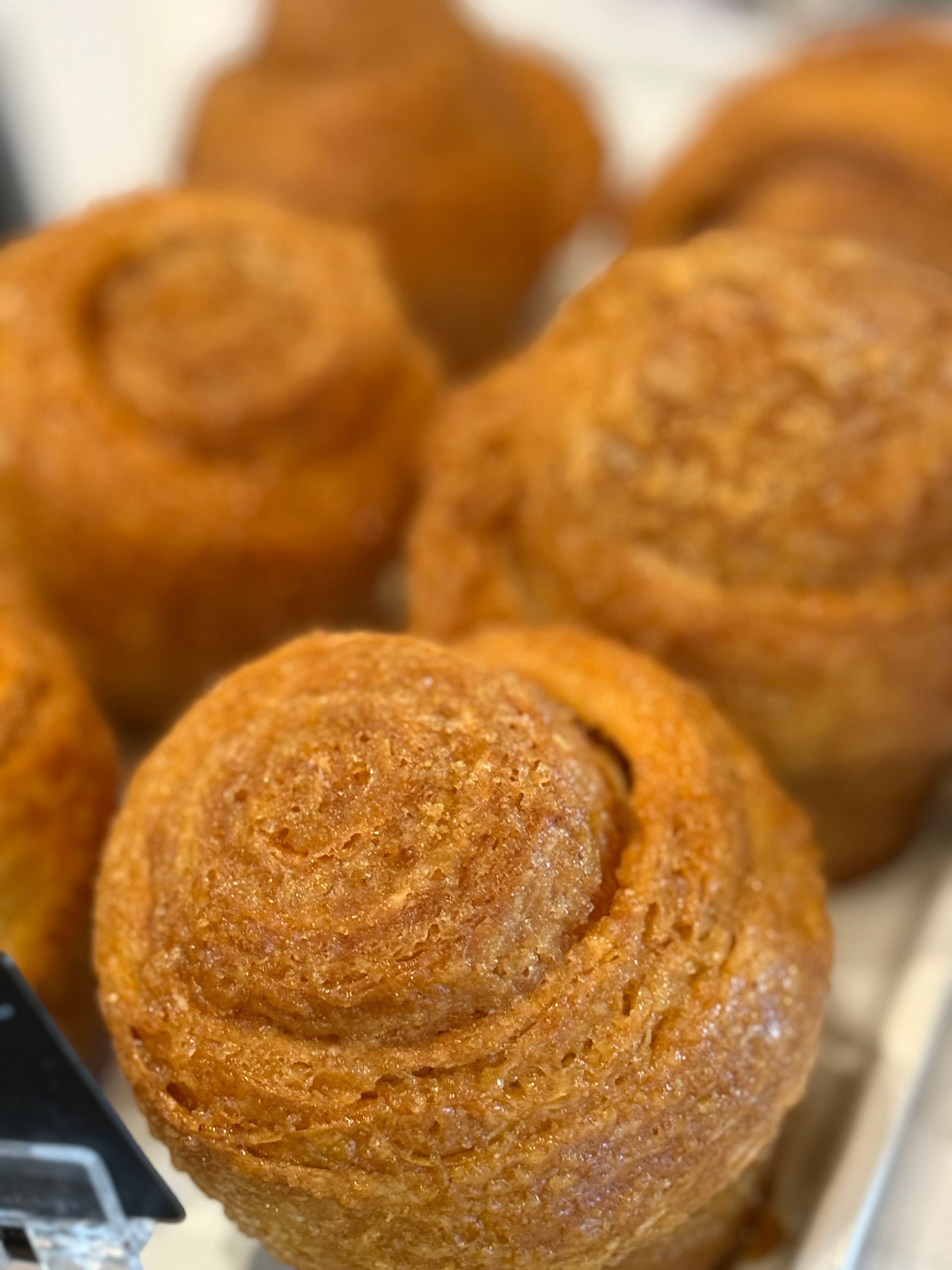 Close-up of several golden, spiral-shaped pastries with textured, crispy surfaces, likely baked goods.