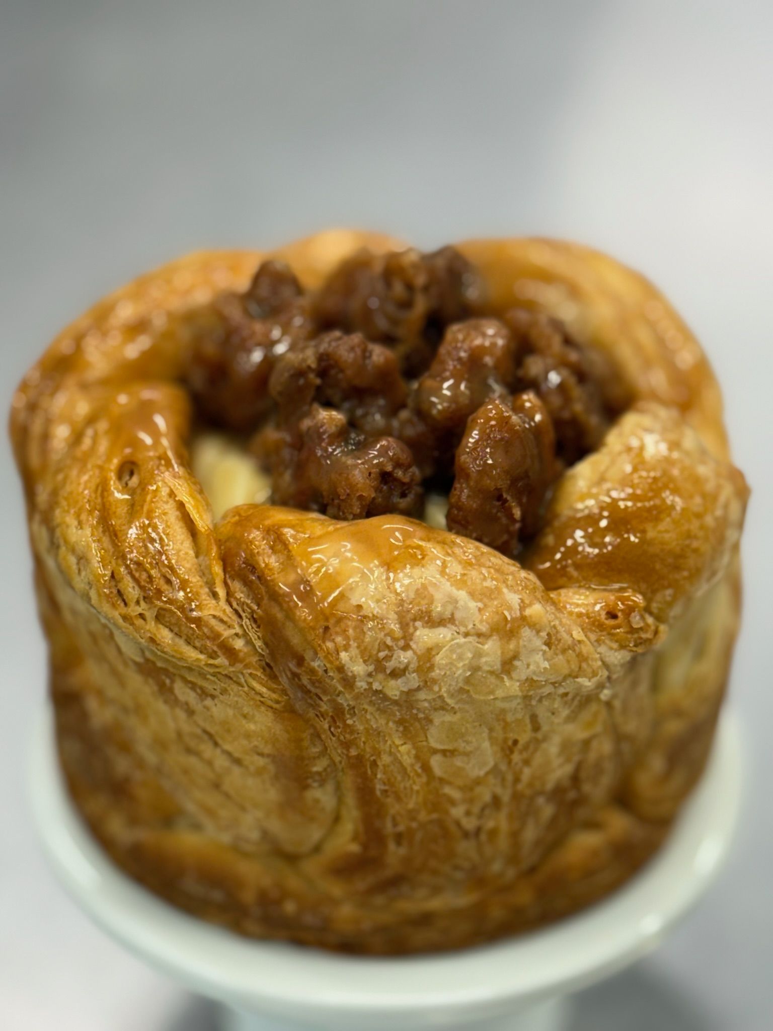Golden pastry with brown filling on a white pedestal.