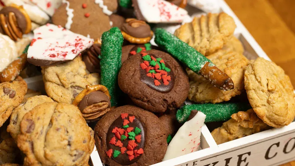 Assorted Christmas cookies in a white box; includes chocolate, gingerbread, and sprinkle decorations.