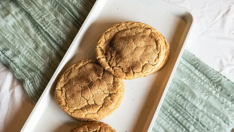 Cookies on a white tray with a green cloth; baked goods.