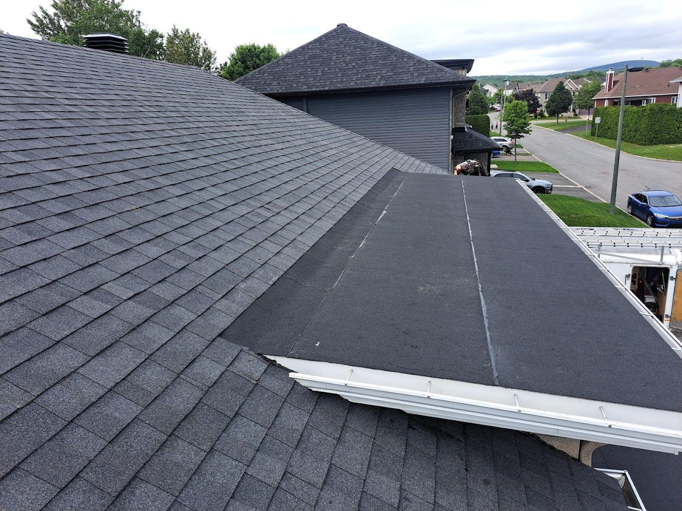 The roof of a house with a black shingle roof