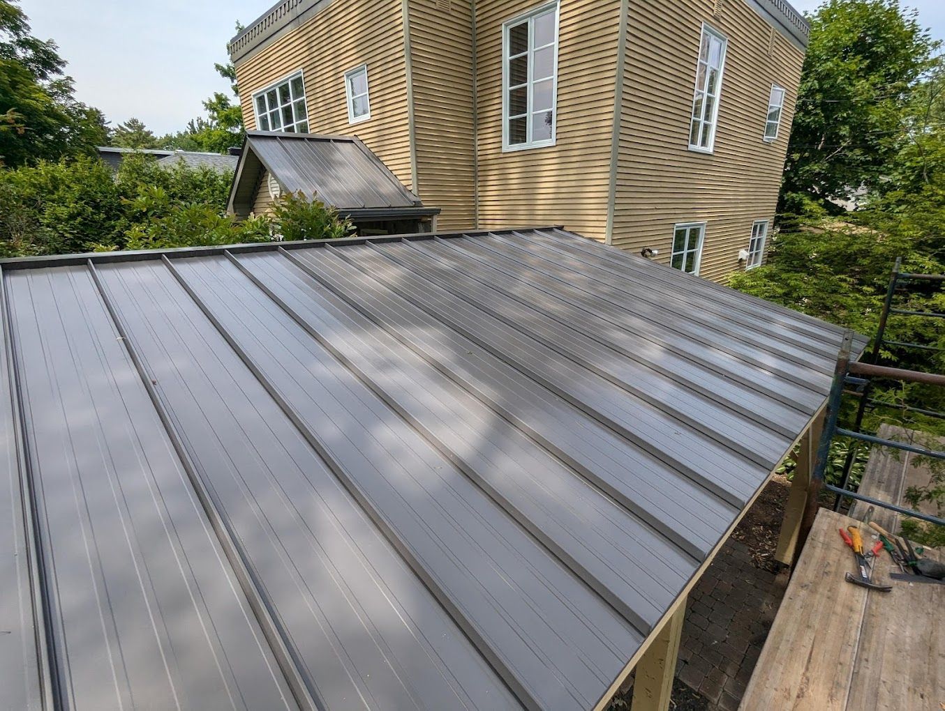 A large house with a metal roof is being built.
