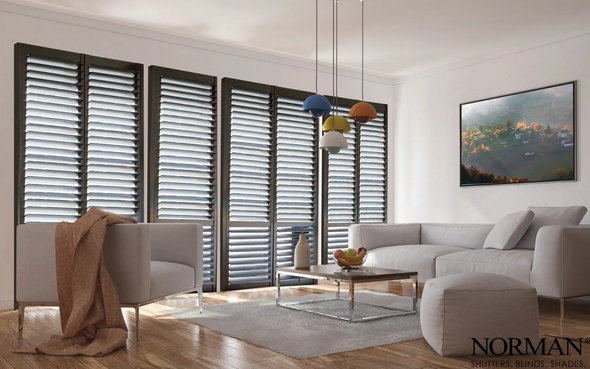 A living room with a couch and chairs and shutters on the windows