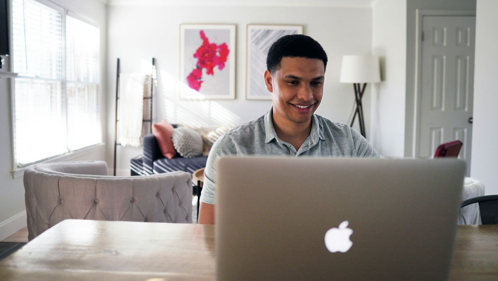 A man is sitting at a desk using a laptop computer.
