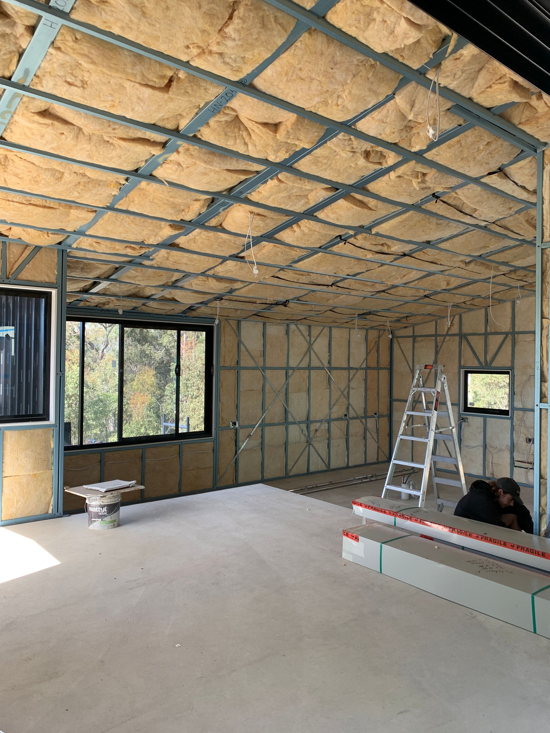 Completed insulation installation in walls and roof of a newly built home.