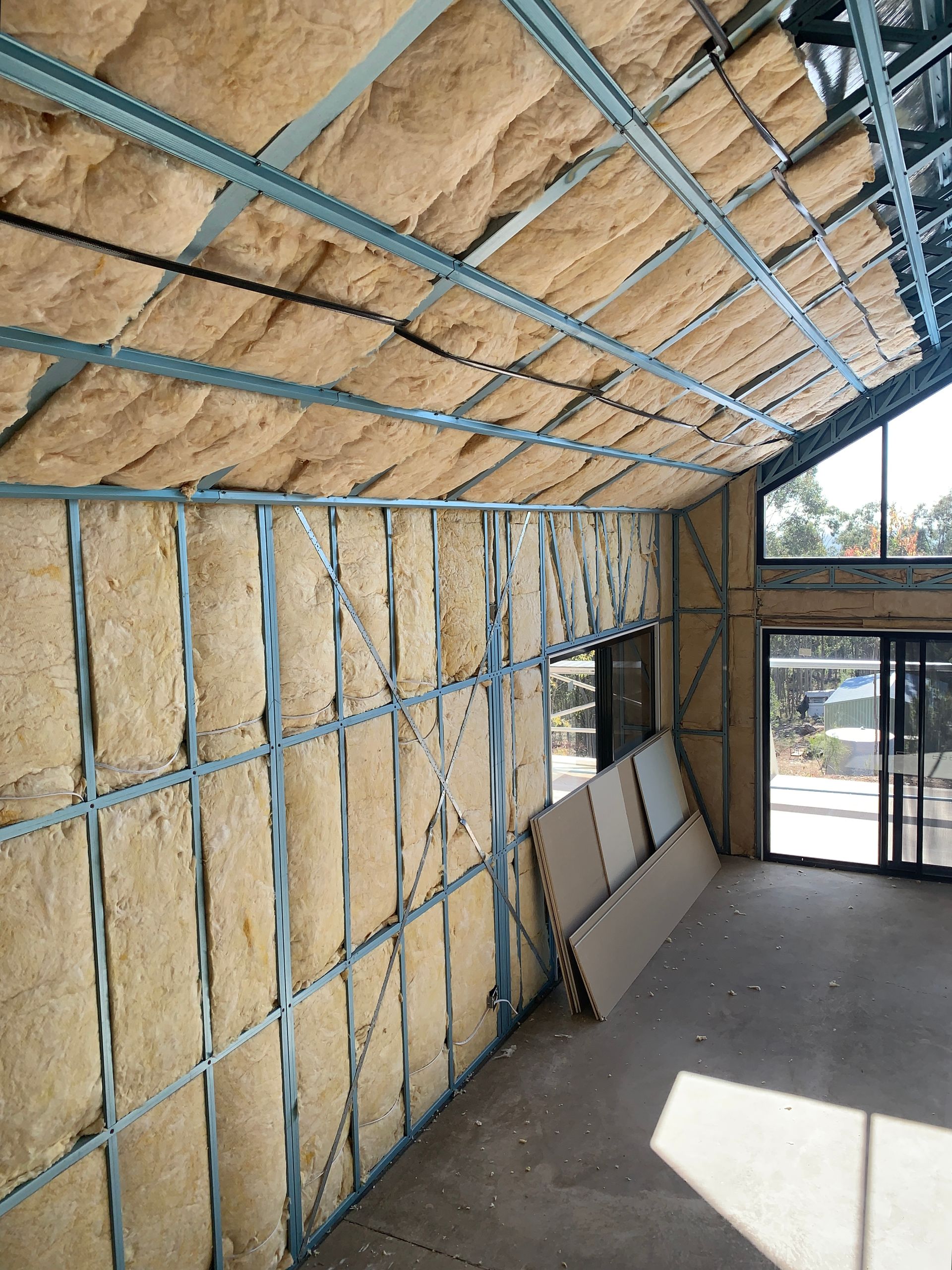 Completed insulation installation in walls and roof of a newly built home.