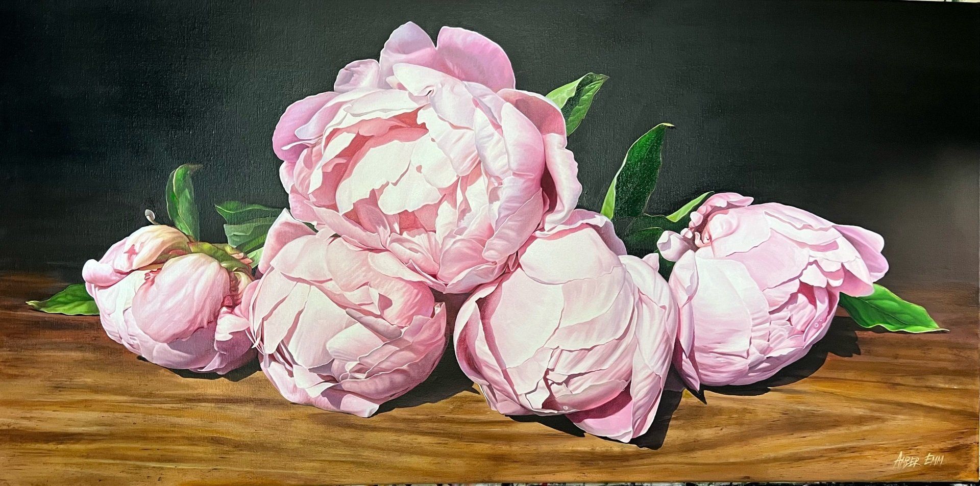 A painting of pink flowers on a wooden table.