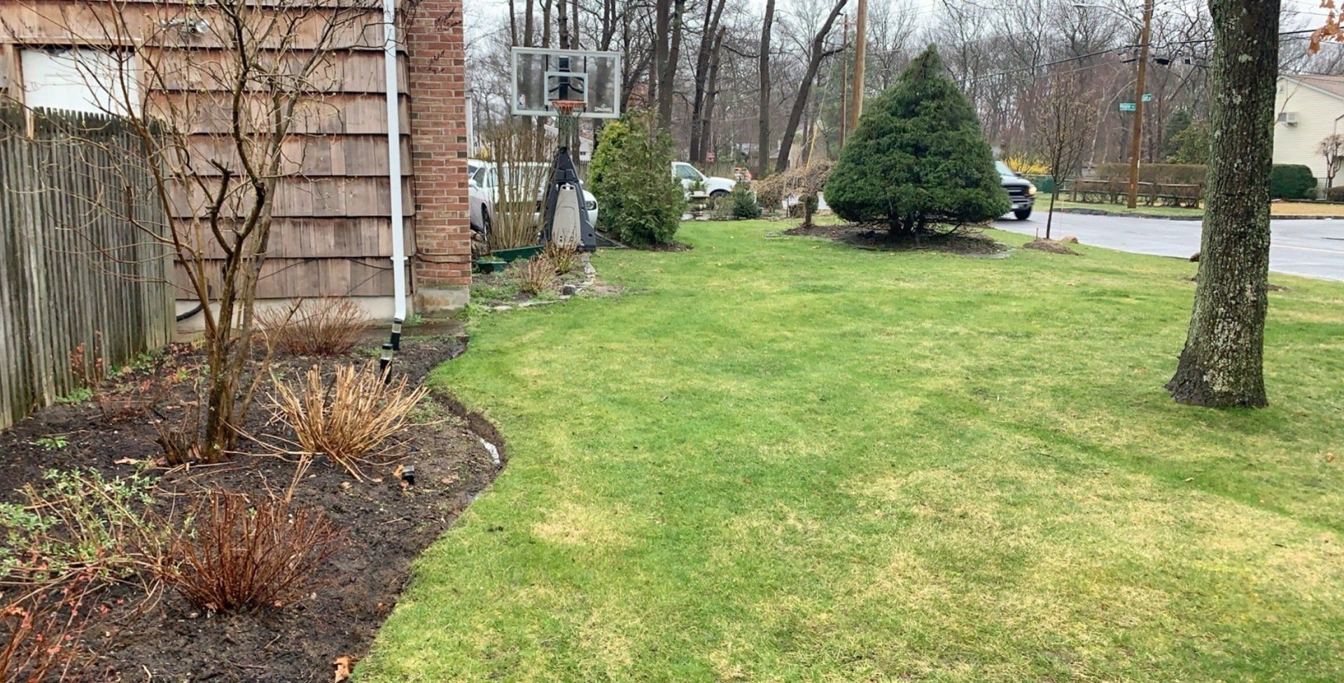 There is a basketball hoop in the backyard of a house.