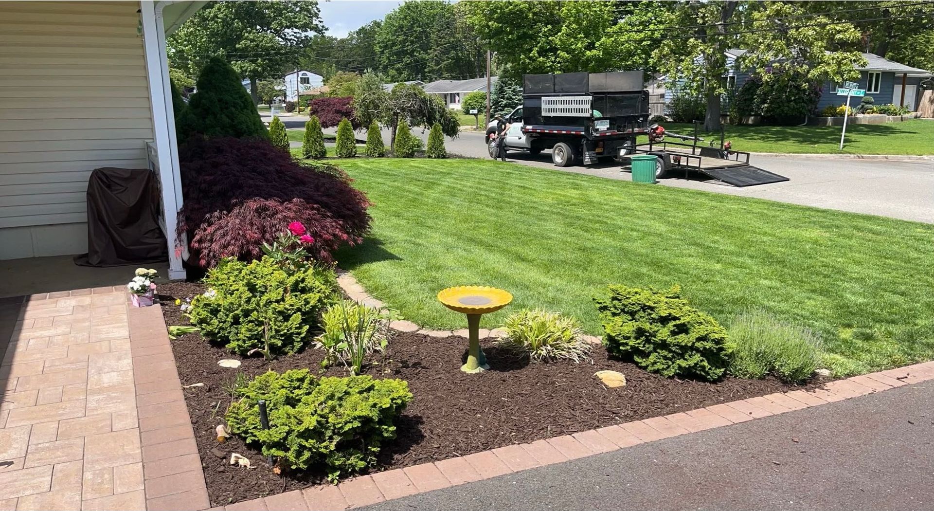 A lush green lawn with a bird bath in the middle of it.