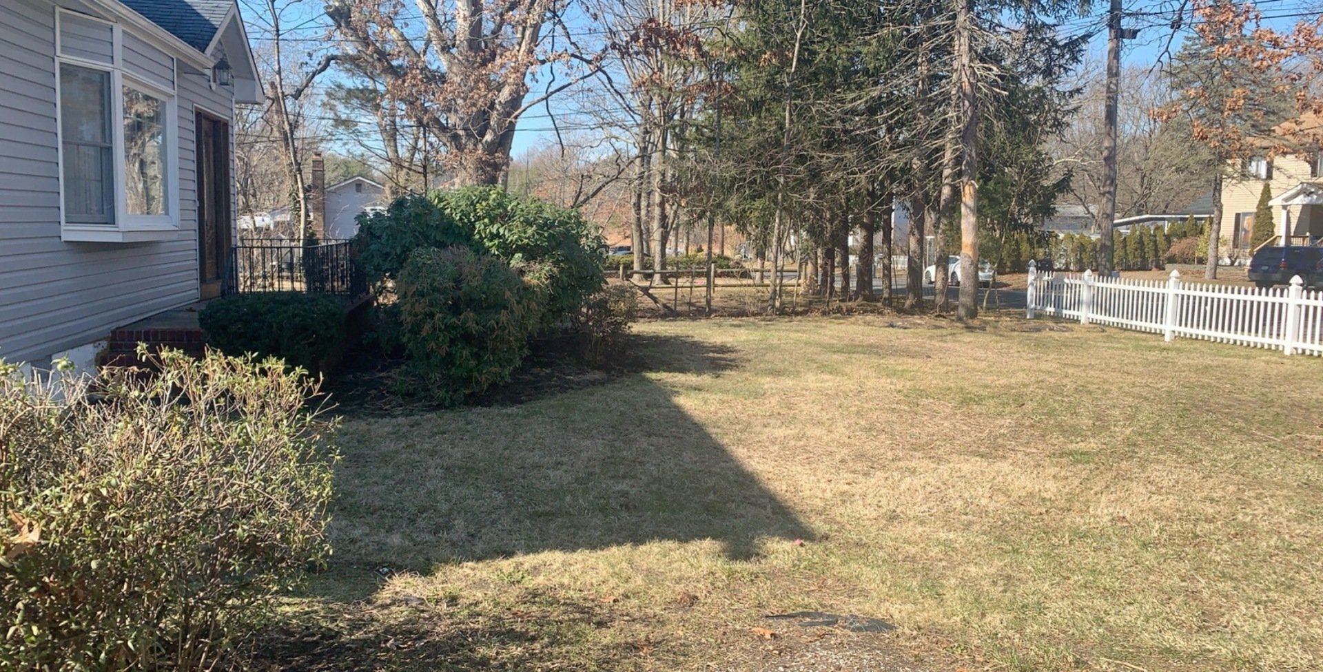 There is a white fence in the backyard of a house.