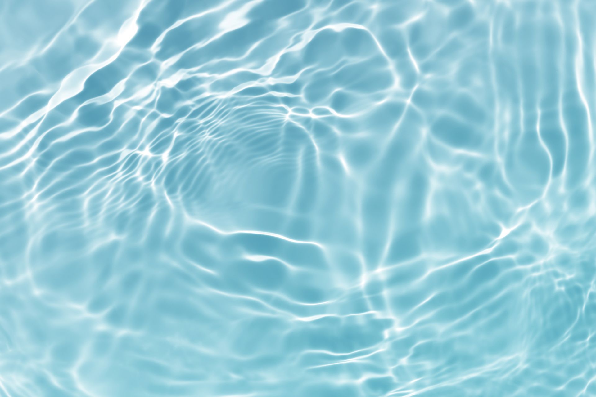 Light blue water surface with rippling patterns and sunlight reflections.