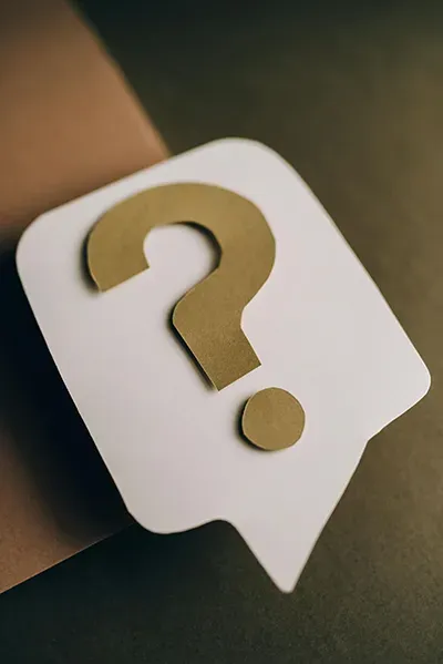 White speech bubble with a gold question mark on a dark background