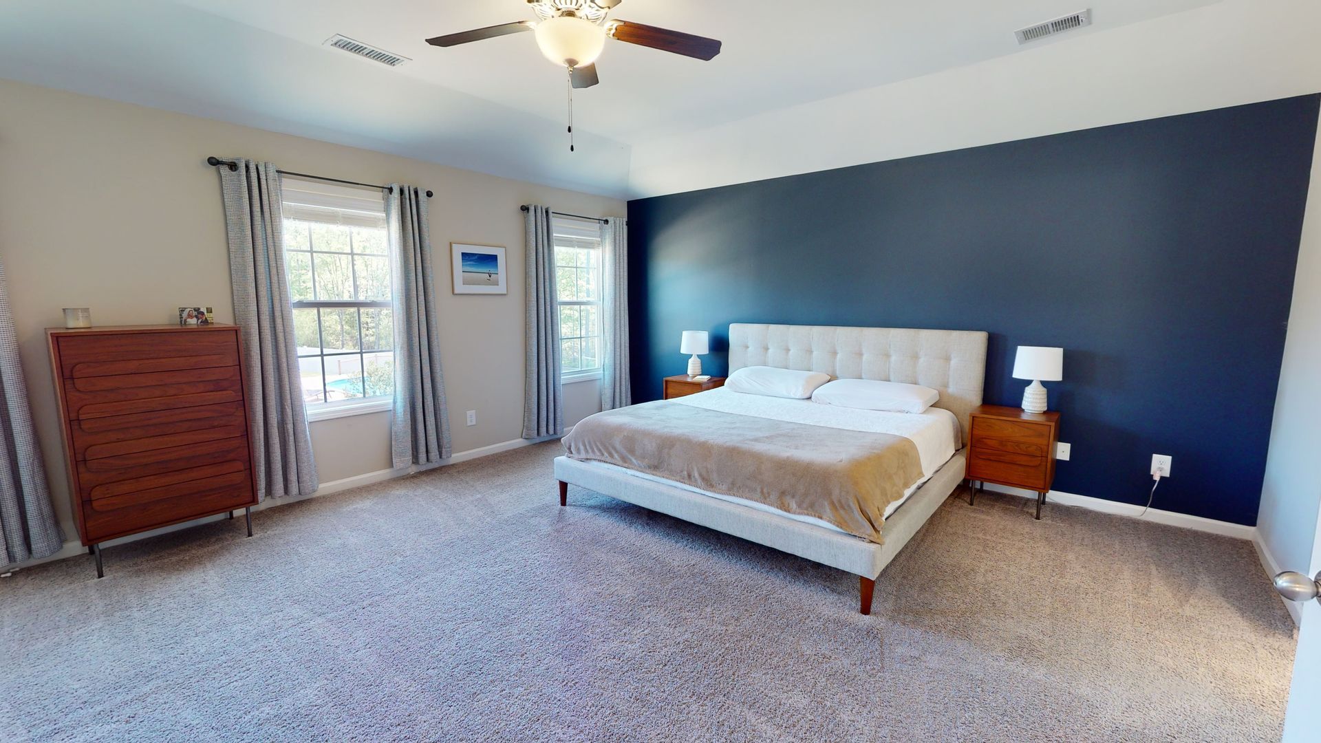 A hotel room with two beds , a couch , a table and a mirror.