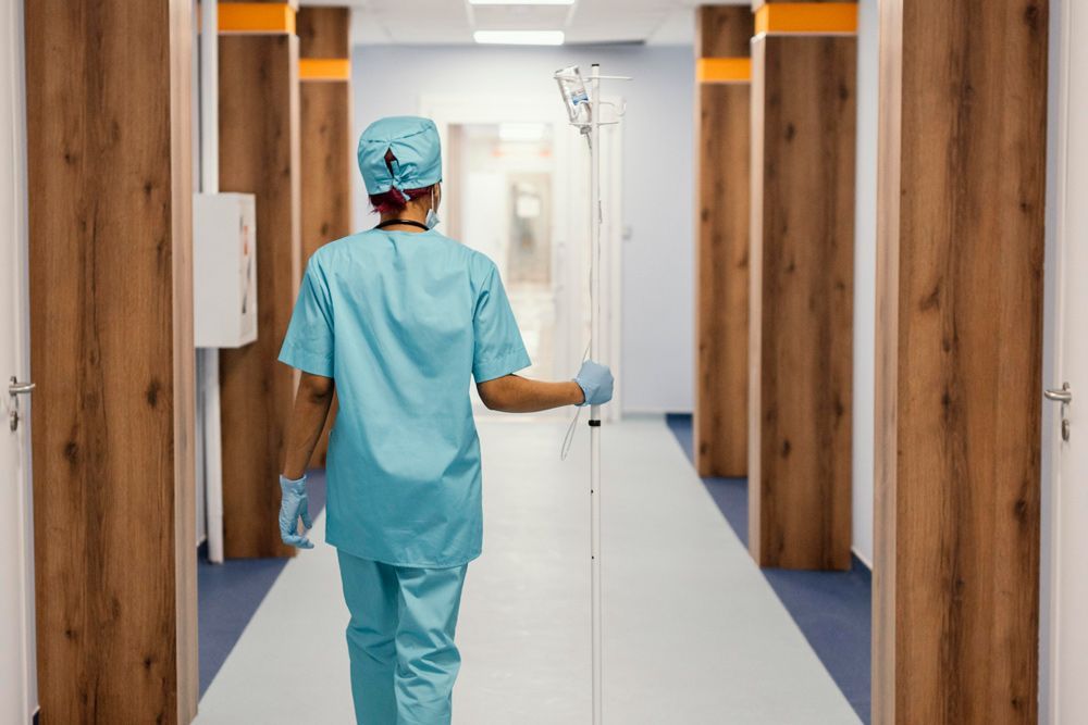 Nurse Walking While Holding a Dextrose Stand