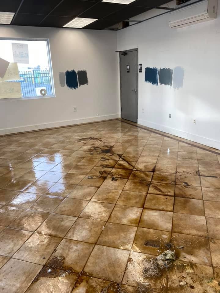 A room with a dirty tile floor and a window.