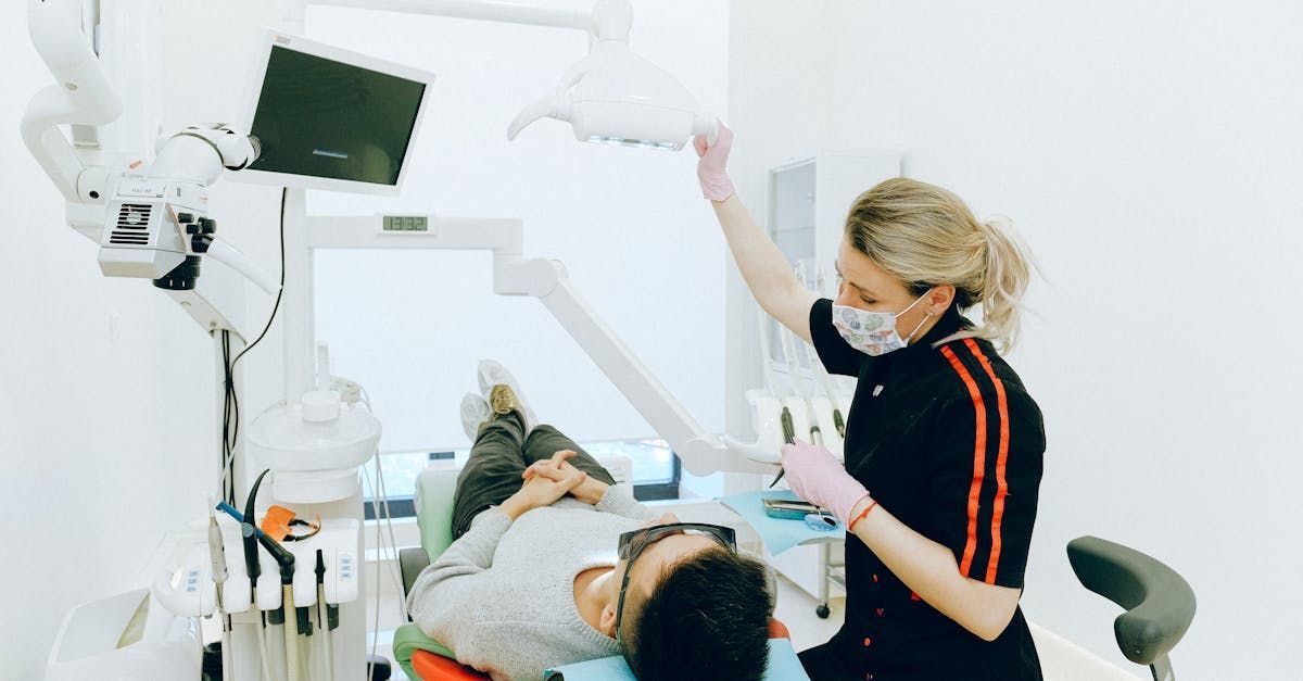 A dentist is examining a patient 's teeth in a dental office.