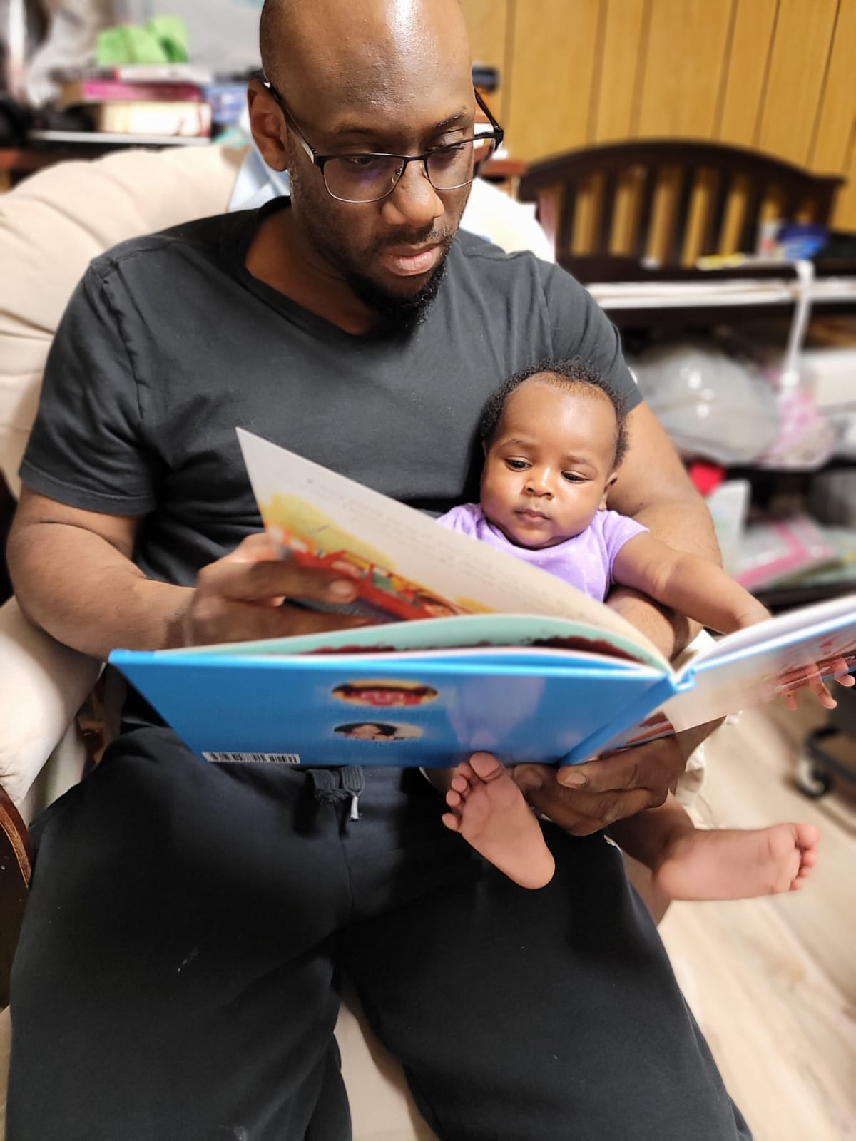 Parent holding baby while reading a page from Zoey has an Allergy book