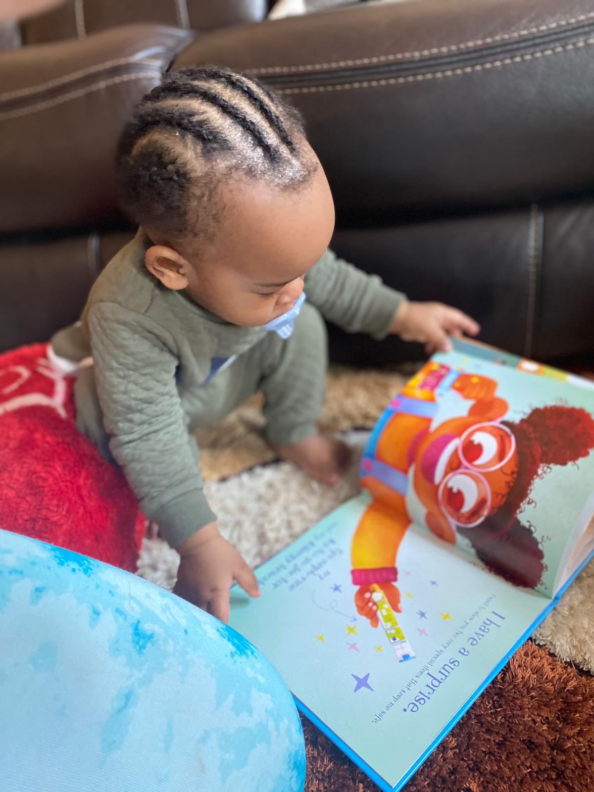 Baby on floor reading a page from Zoey has an Allergy book