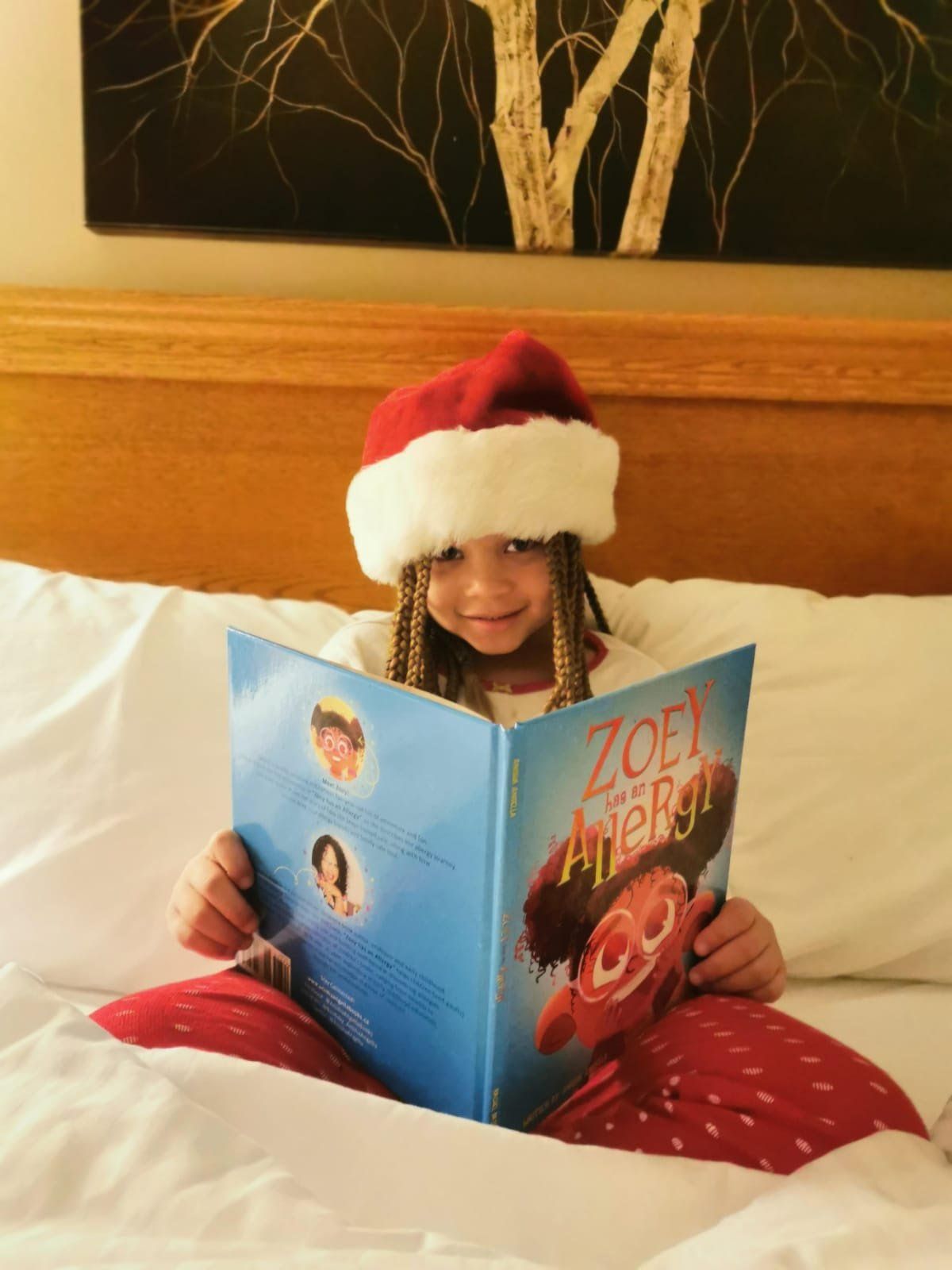 Small child reading Zoey has an Allergy book on the bed