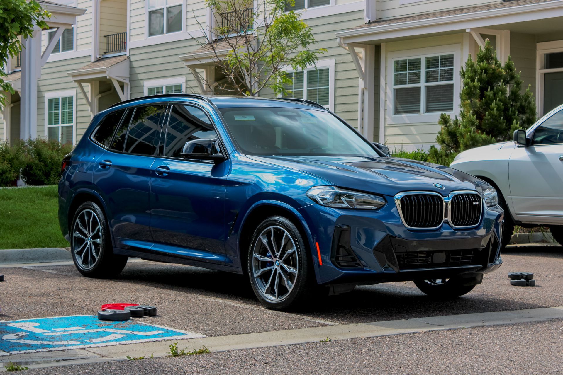 Blue BMW X3 SUV parked in front of a light-colored building.