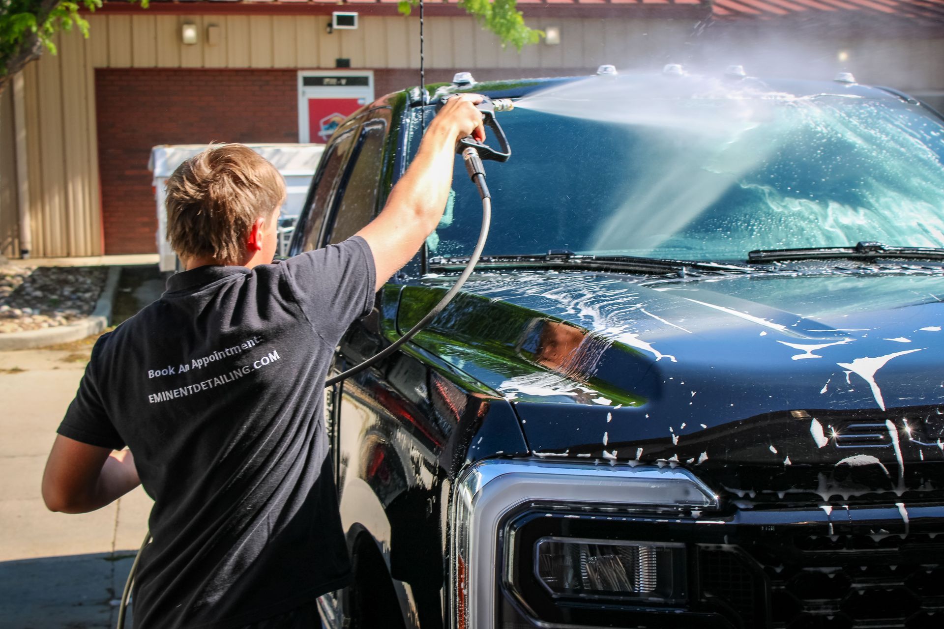 Interior view of a Porsche sports car with black leather seats, dashboard, and steering wheel; door open.